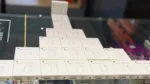 Bulk stock of original Apple Lightning to 3.5mm headphone jack adapters displayed in pyramid arrangement for sale